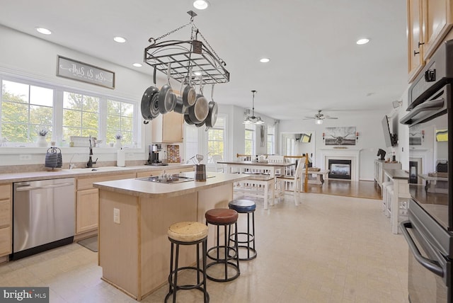 5040 Hummingbird Ln, Warrenton, VA 20187 - kitchen with dishwasher, a fireplace, ceiling fan, light brown cabinetry, and a center island