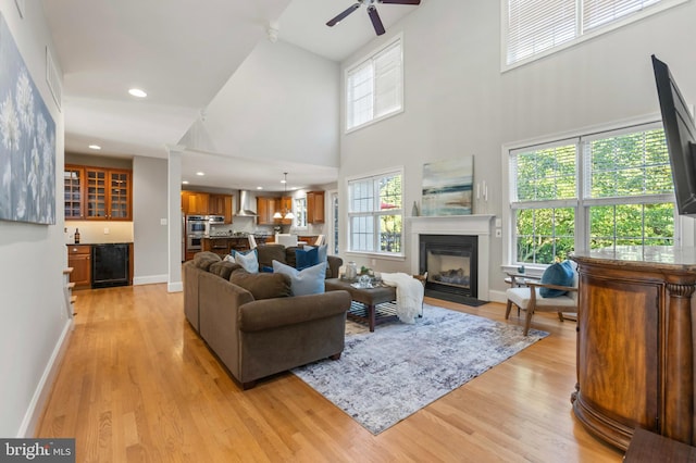 11 Woods Edge Rd, West Chester, PA 19382 - living room featuring wine cooler, a towering ceiling, light wood-type flooring, a fireplace with flush hearth, and ceiling fan