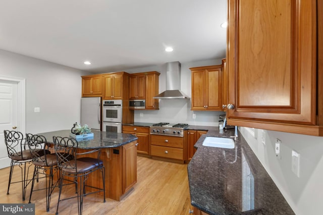 11 Woods Edge Rd, West Chester, PA 19382 - kitchen with wall chimney range hood, appliances with stainless steel finishes, brown cabinetry, a breakfast bar, and recessed lighting