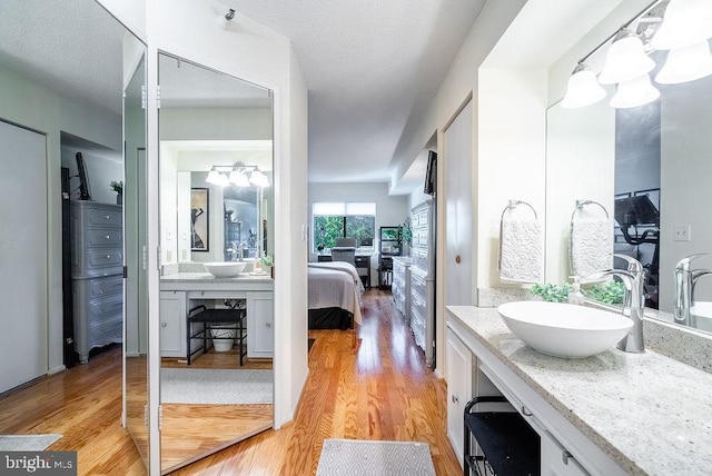 1600 N Oak St Unit 324, Arlington, VA 22209 - bathroom with wood finished floors, connected bathroom, vanity, a chandelier, and a textured ceiling