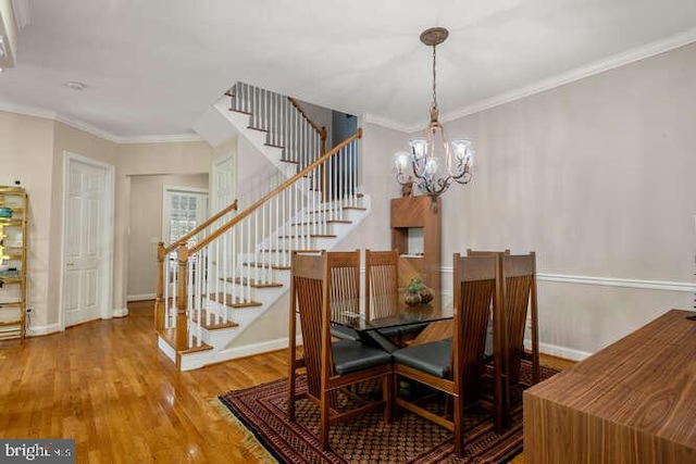 dining space with stairs, a chandelier, wood finished floors, ornamental molding, and baseboards