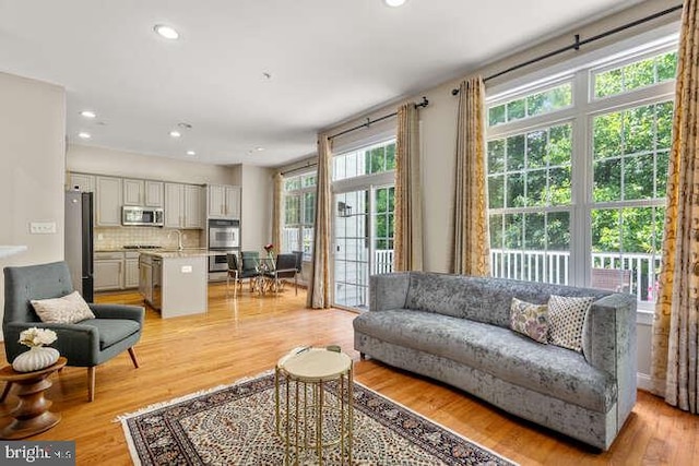 living area featuring light wood-style flooring and recessed lighting