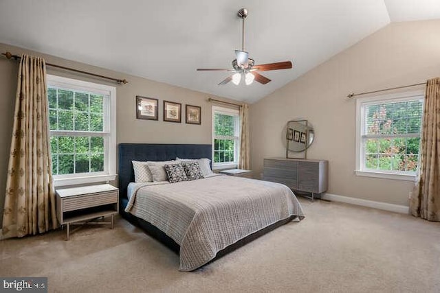 carpeted bedroom with vaulted ceiling, multiple windows, a ceiling fan, and baseboards