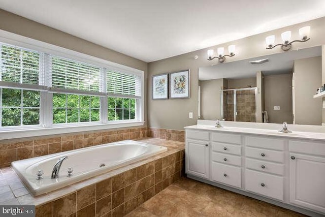 bathroom with a bath, double vanity, a shower stall, and tile patterned floors