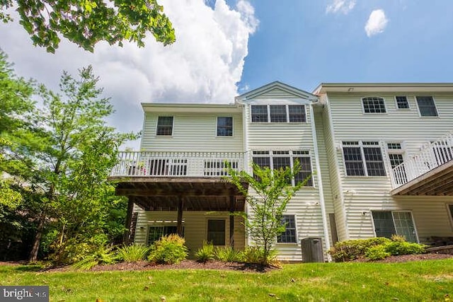 back of house with a wooden deck, cooling unit, and a lawn
