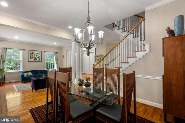dining room featuring baseboards, wood finished floors, ornamental molding, stairs, and a chandelier