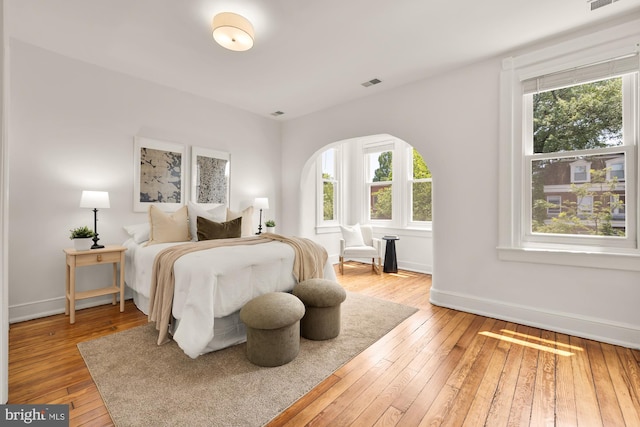 704 F St NE, Washington, DC 20002 - bedroom featuring arched walkways, hardwood / wood-style flooring, and baseboards