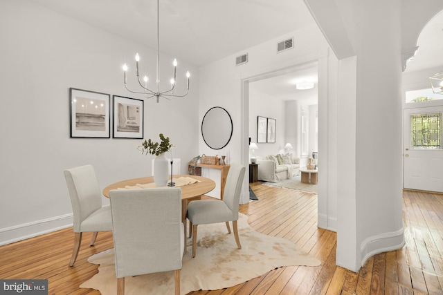 704 F St NE, Washington, DC 20002 - dining room featuring a chandelier, light wood-style floors, and baseboards