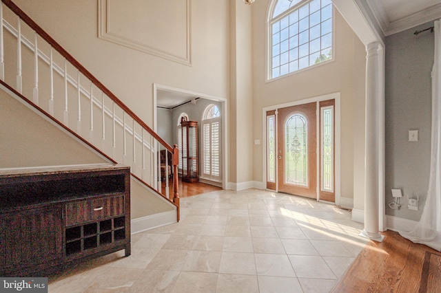 143 Bakerfield Dr, Middletown, DE 19709 - foyer entrance featuring ornate columns, plenty of natural light, stairway, a high ceiling, and ornamental molding