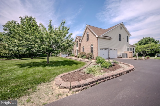 143 Bakerfield Dr, Middletown, DE 19709 - view of property exterior featuring an attached garage, central AC, driveway, a lawn, and brick siding