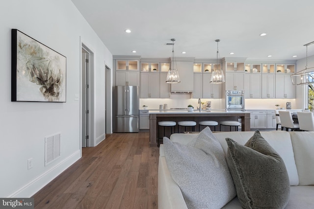 629 S Orange St, Media, PA 19063 - kitchen featuring stainless steel appliances, a kitchen breakfast bar, open floor plan, a kitchen island, and glass insert cabinets