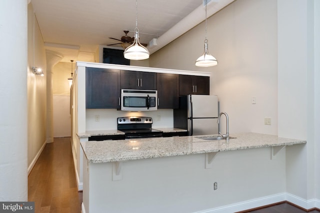 2429 Locust St Unit 319, Philadelphia, PA 19103 - kitchen featuring appliances with stainless steel finishes, a sink, a breakfast bar area, wood finished floors, and a peninsula
