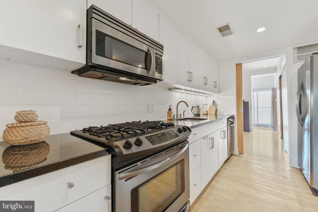961 Randolph St NW Unit 3, Washington, DC 20011 - kitchen featuring appliances with stainless steel finishes, a sink, white cabinetry, decorative backsplash, and recessed lighting
