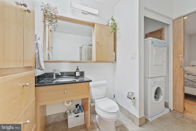 961 Randolph St NW Unit 3, Washington, DC 20011 - bathroom with stacked washer / dryer, toilet, baseboards, vanity, and a shower with door