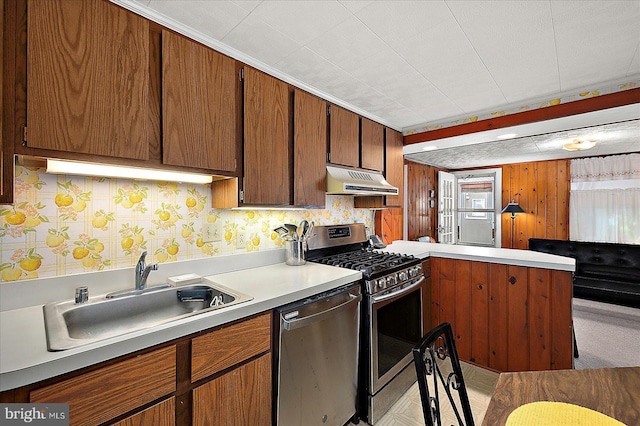 104 11th St, Ocean City, MD 21842 - kitchen with appliances with stainless steel finishes, a sink, under cabinet range hood, a peninsula, and light countertops