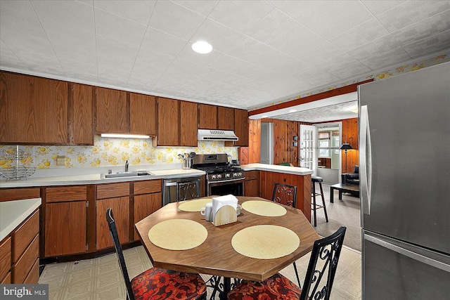 104 11th St, Ocean City, MD 21842 - kitchen with appliances with stainless steel finishes, under cabinet range hood, a sink, light flooring, and light countertops