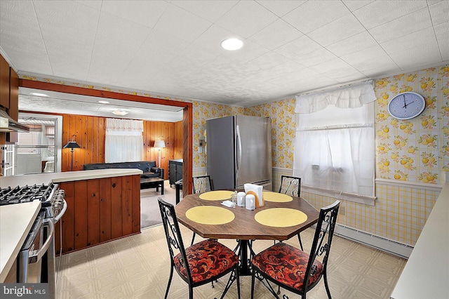 104 11th St, Ocean City, MD 21842 - dining space with wallpapered walls, a baseboard heating unit, light flooring, and wainscoting