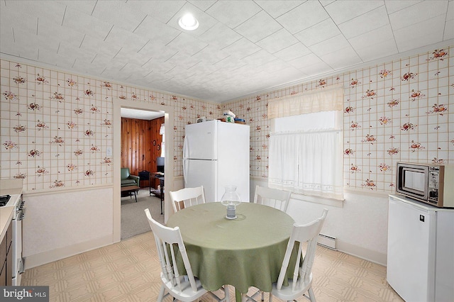 104 11th St, Ocean City, MD 21842 - dining space featuring wallpapered walls, a baseboard radiator, light floors, and baseboards