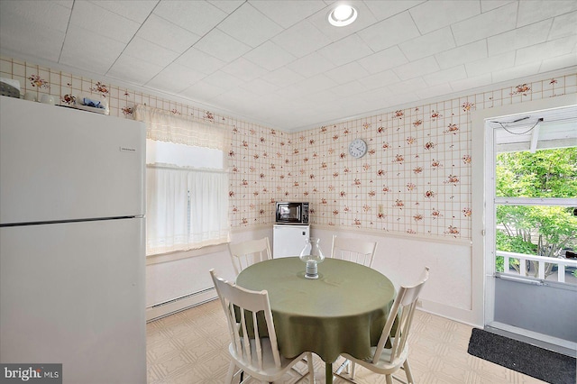 104 11th St, Ocean City, MD 21842 - dining space with tile patterned floors, wallpapered walls, baseboard heating, and wainscoting