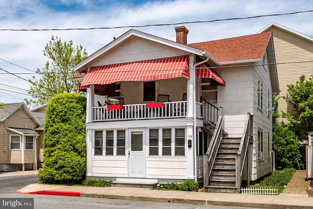104 11th St, Ocean City, MD 21842 - view of front of home with a chimney, stairs, a shingled roof, and a balcony