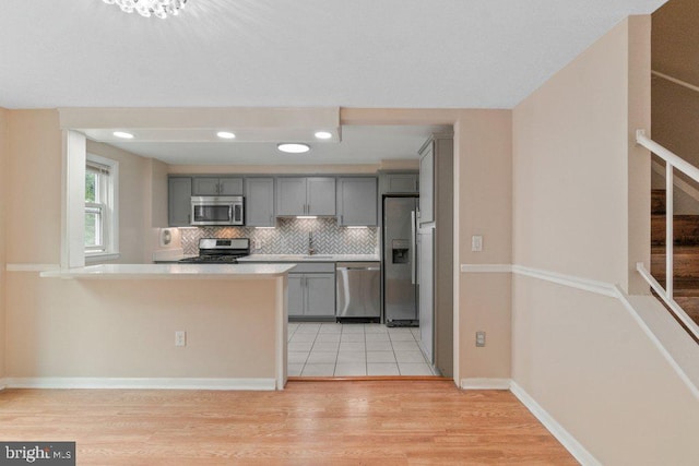 911 Circle Dr, Baltimore, MD 21227 - kitchen with appliances with stainless steel finishes, gray cabinetry, light wood-style floors, tasteful backsplash, and recessed lighting