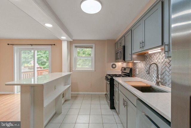 911 Circle Dr, Baltimore, MD 21227 - kitchen with stainless steel appliances, a sink, light countertops, baseboards, and tasteful backsplash