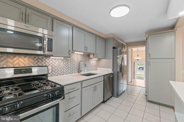 911 Circle Dr, Baltimore, MD 21227 - kitchen featuring stainless steel appliances, gray cabinetry, a sink, and light countertops
