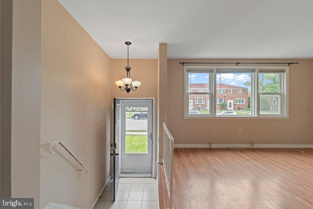 911 Circle Dr, Baltimore, MD 21227 - entrance foyer with plenty of natural light, light wood-style flooring, a chandelier, and baseboards