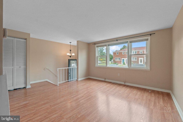 911 Circle Dr, Baltimore, MD 21227 - empty room featuring light wood-style floors, a chandelier, and baseboards