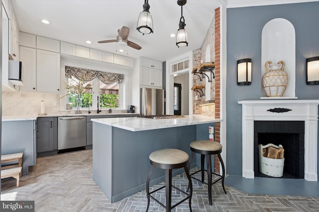 1202 W Wynnewood Rd Unit 1, Wynnewood, PA 19096 - kitchen with stainless steel appliances, a kitchen bar, ceiling fan, backsplash, and a peninsula
