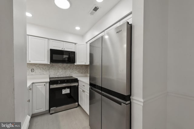 20036 Appledowre Cir Unit 450, Germantown, MD 20876 - kitchen featuring black microwave, freestanding refrigerator, range with electric stovetop, white cabinets, and light countertops