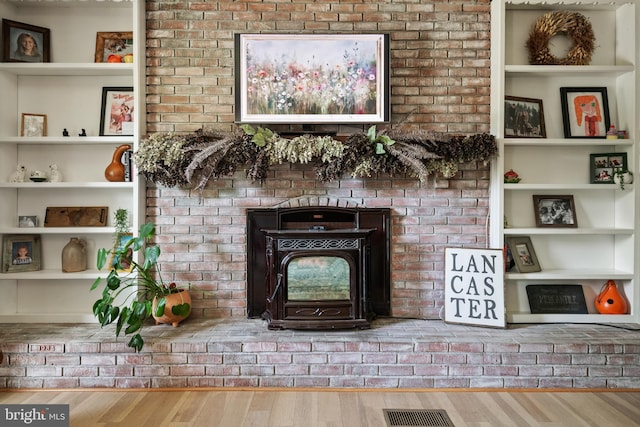 105 Stonewyck Dr, Lancaster, PA 17603 - unfurnished living room featuring wood finished floors, a wood stove, and built in shelves
