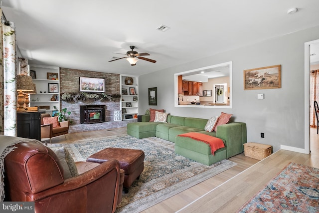 105 Stonewyck Dr, Lancaster, PA 17603 - living room featuring ceiling fan, wood finished floors, a brick fireplace, and baseboards