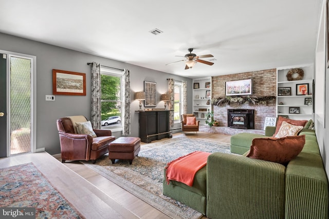105 Stonewyck Dr, Lancaster, PA 17603 - living room with wood finished floors, a ceiling fan, a fireplace, and built in shelves
