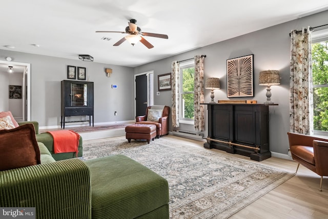 105 Stonewyck Dr, Lancaster, PA 17603 - living area with a baseboard heating unit, a ceiling fan, wood finished floors, and baseboards