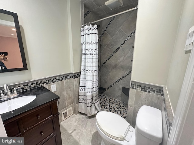 8854 Calvert St, Philadelphia, PA 19152 - full bathroom featuring tile walls, a tile shower, toilet, vanity, and wainscoting