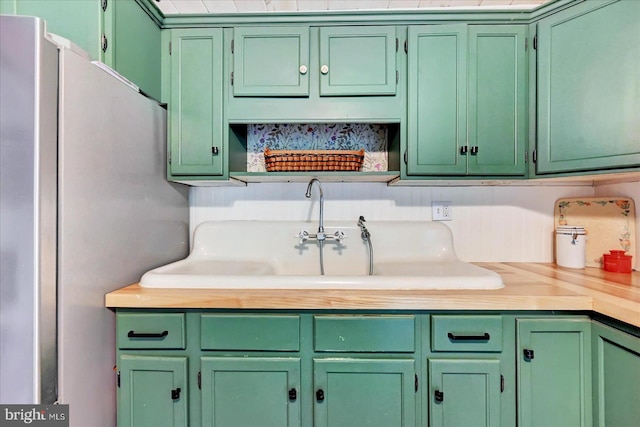 2122 Harkins Rd, Pylesville, MD 21132 - kitchen featuring light countertops, green cabinets, a sink, and freestanding refrigerator