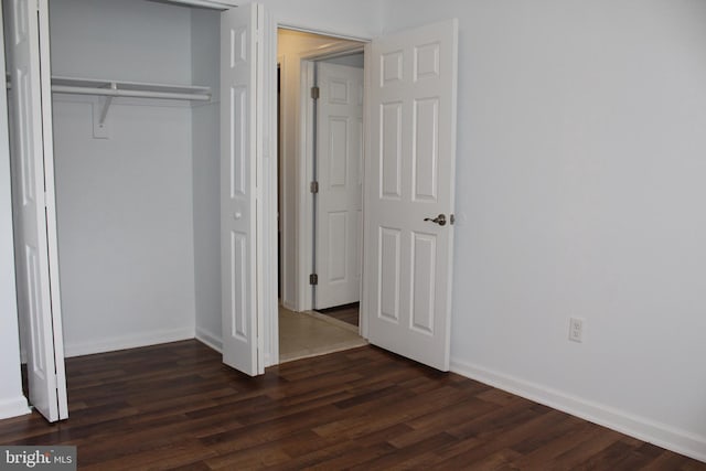 104 Duvall Ln Unit 30-104, Gaithersburg, MD 20877 - unfurnished bedroom featuring a closet, dark wood-style floors, and baseboards