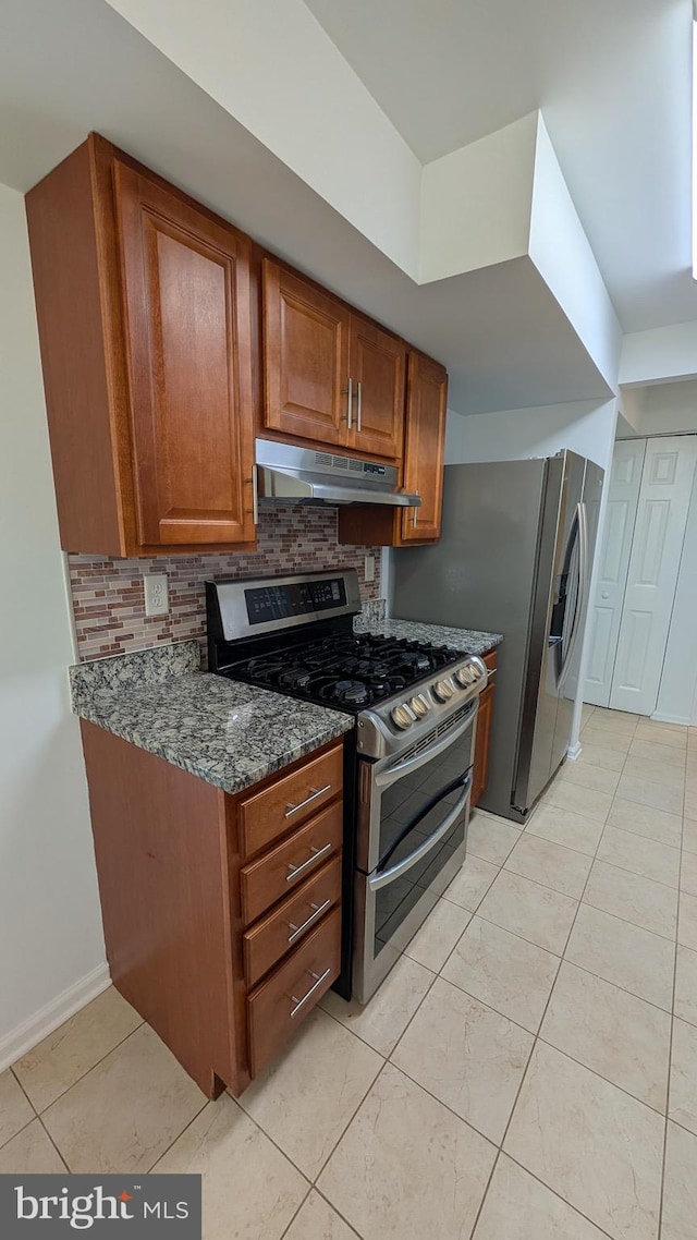 104 Duvall Ln Unit 30-104, Gaithersburg, MD 20877 - kitchen featuring stainless steel appliances, under cabinet range hood, backsplash, dark stone countertops, and brown cabinets