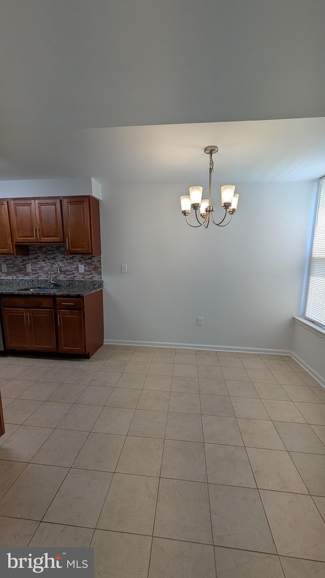 104 Duvall Ln Unit 30-104, Gaithersburg, MD 20877 - kitchen with a chandelier, backsplash, a sink, decorative light fixtures, and baseboards