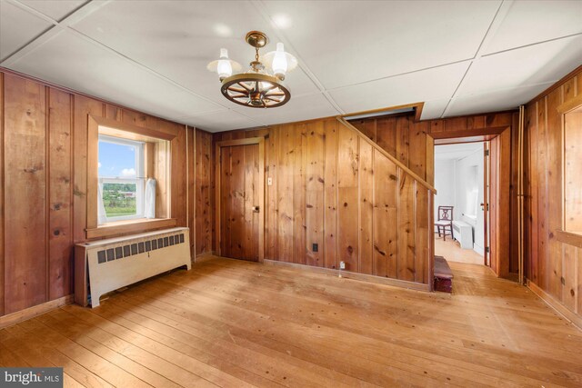 2138 Hill Rd, Perkiomenville, PA 18074 - unfurnished dining area with radiator, wood walls, hardwood / wood-style floors, and a chandelier