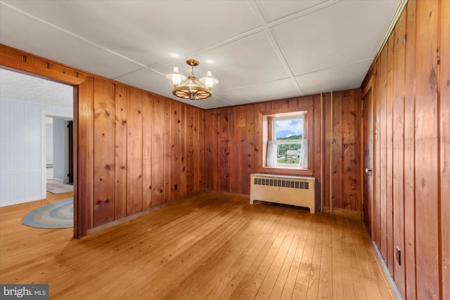 2138 Hill Rd, Perkiomenville, PA 18074 - unfurnished room featuring radiator heating unit, light wood finished floors, a chandelier, and wooden walls