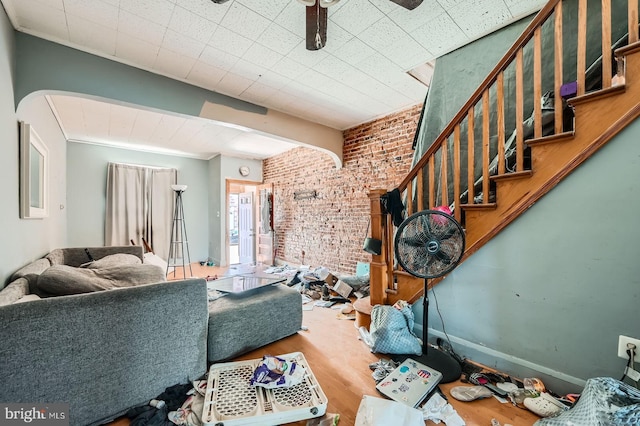 12 Kresson St N, Baltimore, MD 21224 - living area featuring brick wall, wood finished floors, stairway, arched walkways, and a ceiling fan