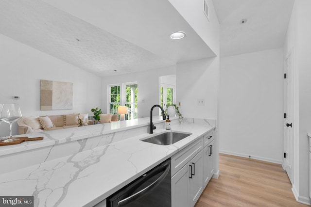 1490 Greenbriar Cir Unit 1-1490, Pikesville, MD 21208 - kitchen featuring dishwashing machine, a sink, light stone counters, open floor plan, and lofted ceiling