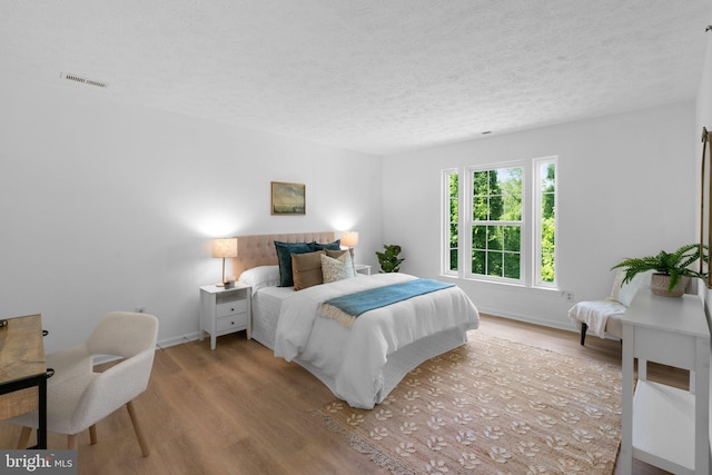 1490 Greenbriar Cir Unit 1-1490, Pikesville, MD 21208 - bedroom featuring wood finished floors, a textured ceiling, and baseboards
