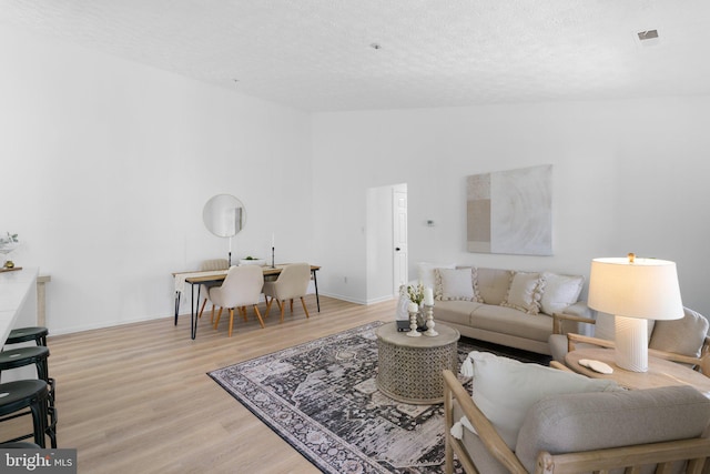 1490 Greenbriar Cir Unit 1-1490, Pikesville, MD 21208 - living area with wood finished floors, lofted ceiling, baseboards, and a textured ceiling