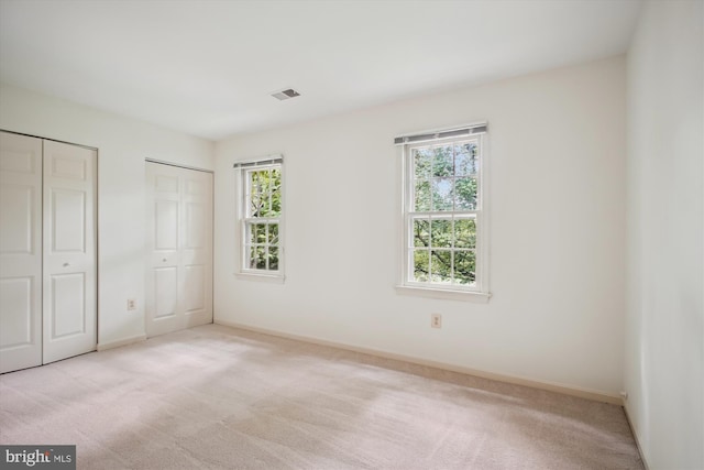 1881 Cold Creek Ct, Vienna, VA 22182 - unfurnished bedroom featuring multiple closets, multiple windows, light colored carpet, and baseboards