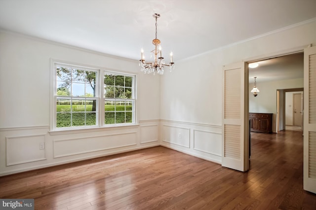 1881 Cold Creek Ct, Vienna, VA 22182 - empty room with a chandelier, a wainscoted wall, ornamental molding, wood finished floors, and a decorative wall