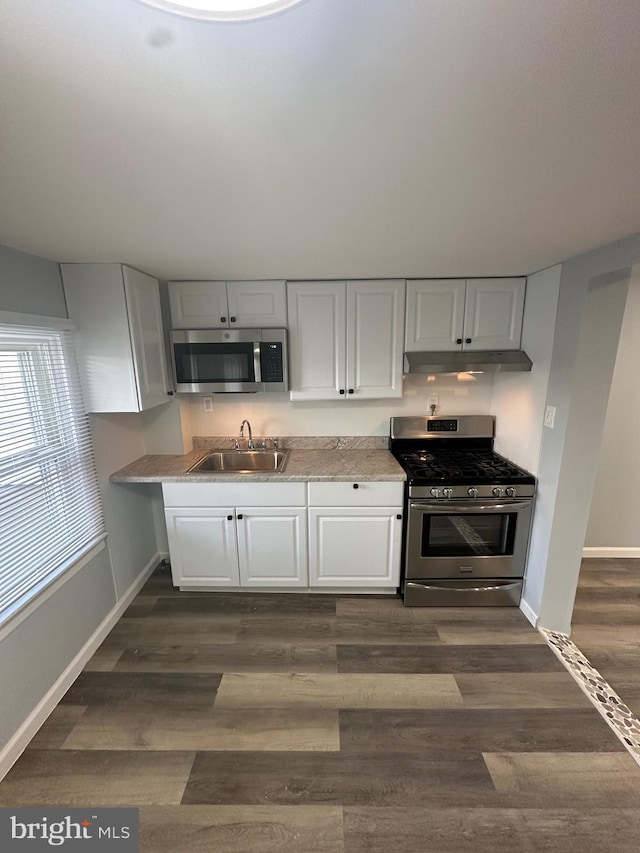 1500 Centre Ave, Reading, PA 19601 - kitchen featuring appliances with stainless steel finishes, a sink, white cabinets, under cabinet range hood, and light countertops