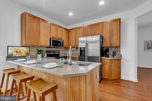 620 Cypress Ln, Severna Park, MD 21146 - kitchen featuring appliances with stainless steel finishes, a peninsula, decorative backsplash, light wood finished floors, and recessed lighting